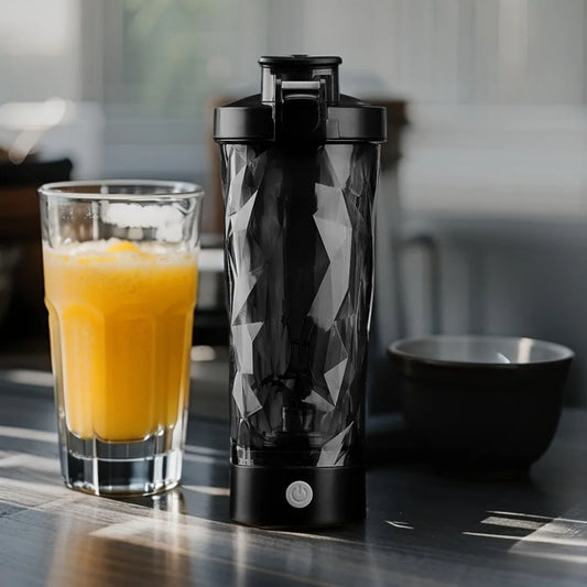 Black portable protein shaker bottle with orange juice glass
