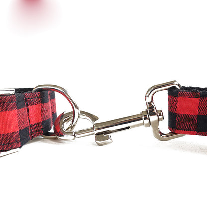 Close-up view of red and black grid dog leash with metal clip attachment